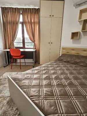 a bedroom with a bed and a desk and a red chair at FOUR SEASONS Beach Apartment in Pomorie