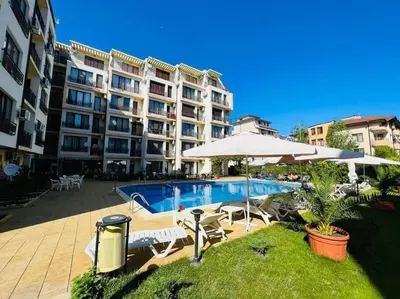 a large apartment building with a swimming pool and an umbrella at Best Location in Sunny Beach Amber Beach in Sunny Beach