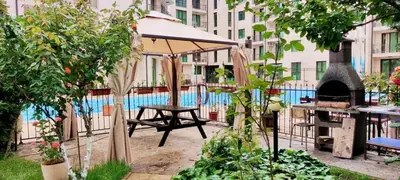 a patio with an umbrella and a table with a fireplace at Best Location in Sunny Beach Amber Beach in Sunny Beach