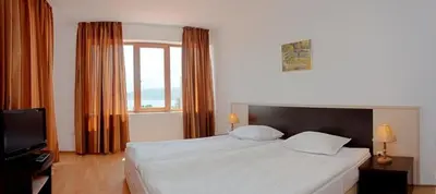 a bedroom with a large white bed and a window at Вили Vemara club in Byala