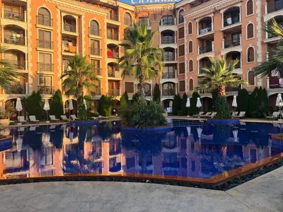 a hotel with a pool in front of a building at Cascadas in Ravda