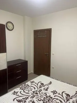 a bedroom with a bed and a dresser and a clock at Cascadas in Ravda