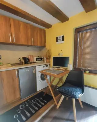 a kitchen with a table and a desk with a computer at Tiny House in the center of Varna in Varna City