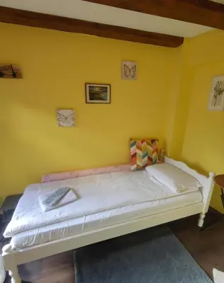 a bed in a room with a yellow wall at Tiny House in the center of Varna in Varna City