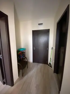 a hallway with a door and a chair and a table at Апартамент Cascadas in Sunny Beach
