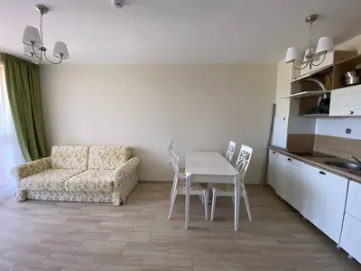 a living room with a table and chairs and a couch at Апартамент Cascadas in Sunny Beach