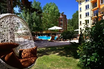 a swing in a yard next to a pool at Marvel Delux Private Studio in Sunny Beach