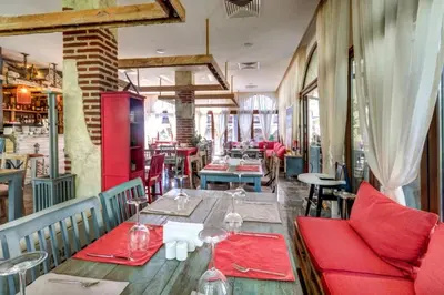 a restaurant with wooden tables and red chairs at Poseidon Nessebar Private Apartment in Nesebar