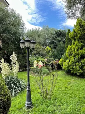 a black lamp post in the grass in a garden at Poseidon Nessebar Private Apartment in Nesebar