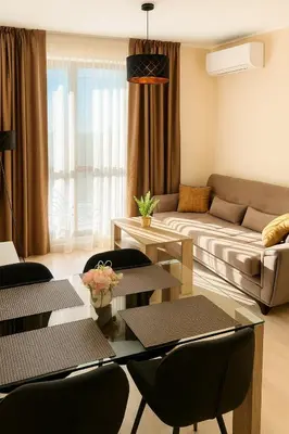 a living room with a couch and a table and chairs at Poseidon Nessebar Private Apartment in Nesebar