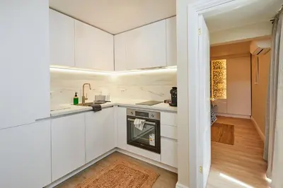 a kitchen with white cabinets and a sink at Apartment Hristo in Pomorie