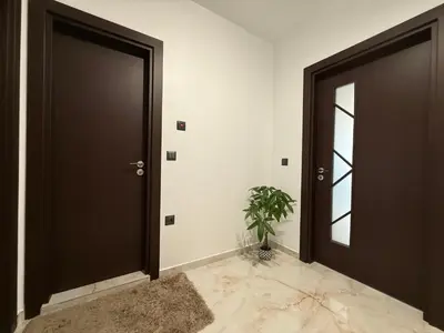 a hallway with two doors and a potted plant at Tea'S Apartment in Varna City