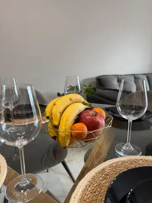 a bowl of fruit on a table with two wine glasses at Tea'S Apartment in Varna City