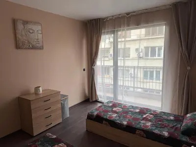 a bedroom with a bed and a large window at Tea'S Apartment in Varna City