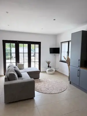 a large living room with a couch and a tv at Garden Villa 2 Bedroom Villa with pool near to Sunny beach in Aleksandrovo