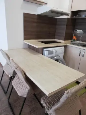 a kitchen with a table and chairs in a kitchen at Apartamenti Zhelezovi in Pomorie
