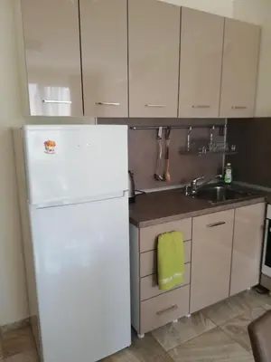 a kitchen with a white refrigerator and a sink at Apartamenti Zhelezovi in Pomorie