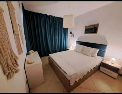 a bedroom with a bed and a blue curtain at Top Oasis Park Lozenets apartment in Lozenets