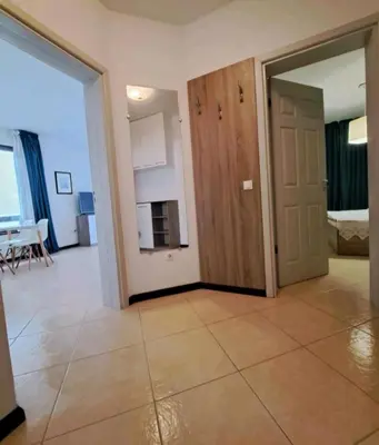 an empty living room with a door and a kitchen at Top Oasis Park Lozenets apartment in Lozenets