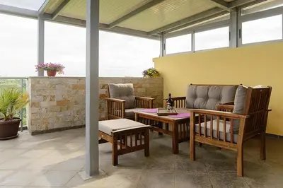 a patio with chairs and a couch and a table at Villa SeaBreeze in Varna City