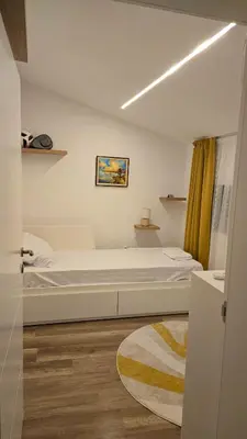 a bedroom with a white bed and a rug at Morava 1 Asparuhovo Beach Holiday House in Varna City