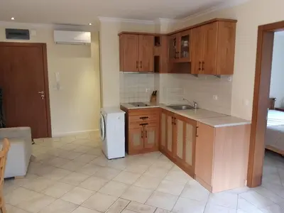 a kitchen with wooden cabinets and a white refrigerator at Трёхкомнатные роскошные апартаменты у моря в Санта Марина in Sozopol