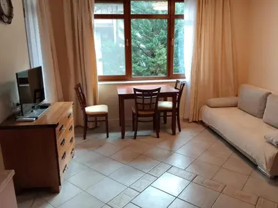 a living room with a table and a couch at Трёхкомнатные роскошные апартаменты у моря в Санта Марина in Sozopol