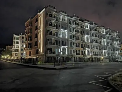 a large apartment building at night in a parking lot at Polarstar Beach Bulgarien Sveti Vlas in Sveti Vlas