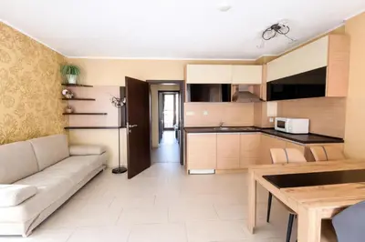 a living room with a couch and a kitchen at Harmony Suites-1 Private Apartment 42А in Sunny Beach