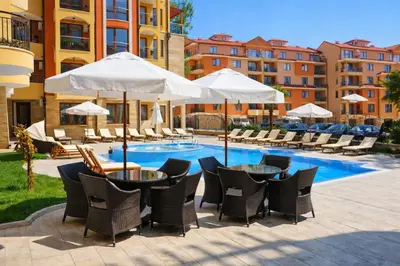a patio with tables and chairs next to a pool at Harmony Suites-1 Private Apartment 42А in Sunny Beach