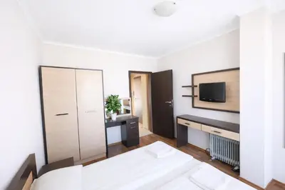 a bedroom with a bed and a tv on a wall at Harmony Suites-1 Private Apartment 42А in Sunny Beach
