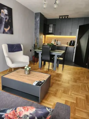 a living room with a table and a kitchen at Апартамент 8 in Varna City