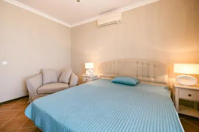 a bedroom with a blue bed and a chair at LUXURY APARTMENT Sozopolis in Sozopol