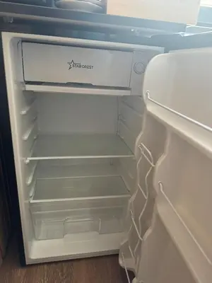 an empty refrigerator with its door open in a room at Room de Port in Burgas City