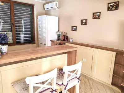 a kitchen with two white chairs at a counter at Private Villa in Elenite Resort in Atanasovo