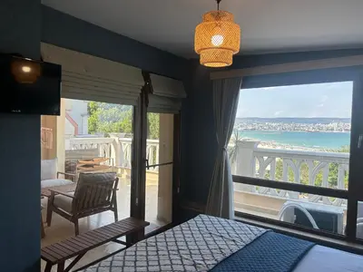a bedroom with a bed and a view of the ocean at Wavehaven Apartment at South Bay in Varna City