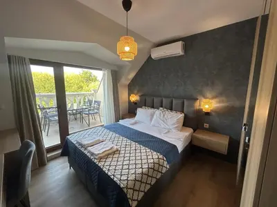 a hotel room with a bed and a balcony at Wavehaven Apartment at South Bay in Varna City