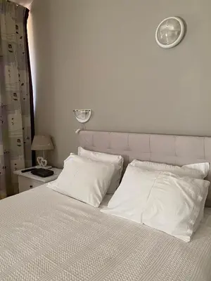 a bed with white sheets and pillows in a bedroom at Spacious Modern Two-Bedroon Suite in Elit 1 Complex in Sunny Beach