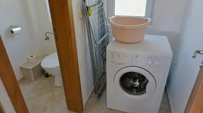 a washing machine with a bucket on top of it at вила Мариела - villa Mariela in Yunets