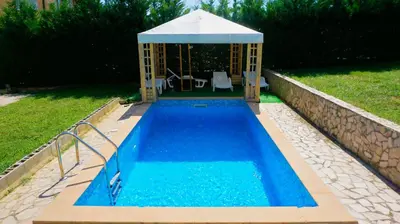 a swimming pool with a gazebo in a yard at вила Мариела - villa Mariela in Yunets