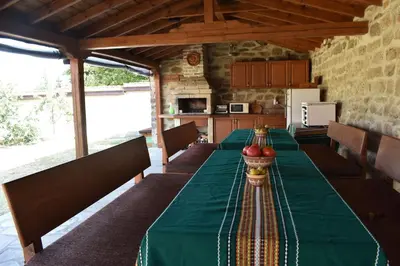 a long table with a green table cloth and apples on it at Коларова къща in Avren