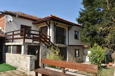 a wooden bench in front of a house at Коларова къща in Avren