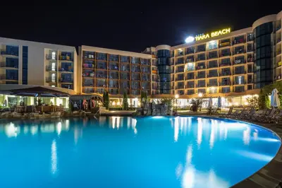 a large pool in front of a hotel at night at Tiara Beach - All Inclusive in Sunny Beach