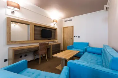 a living room with blue chairs and a table and a television at Tiara Beach - All Inclusive in Sunny Beach