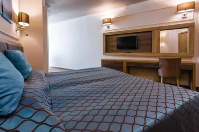 a hotel room with a bed and a television at Tiara Beach - All Inclusive in Sunny Beach