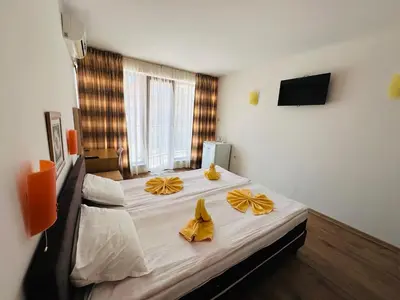 a bedroom with a large bed with yellow bows on it at Hotel Energy in Kiten