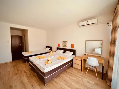 a bedroom with two beds and a desk and a mirror at Hotel Energy in Kiten