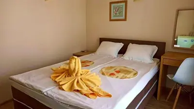 a bedroom with a bed with a yellow towel on it at Hotel Energy in Kiten