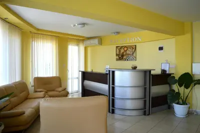 a waiting room with a couch and a reception desk at Family Hotel Coral in Sozopol