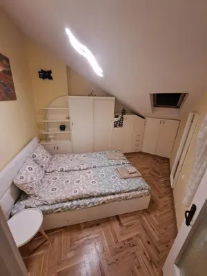 a small bedroom with a bed and a wooden floor at Varna city breaks 1 in Varna City